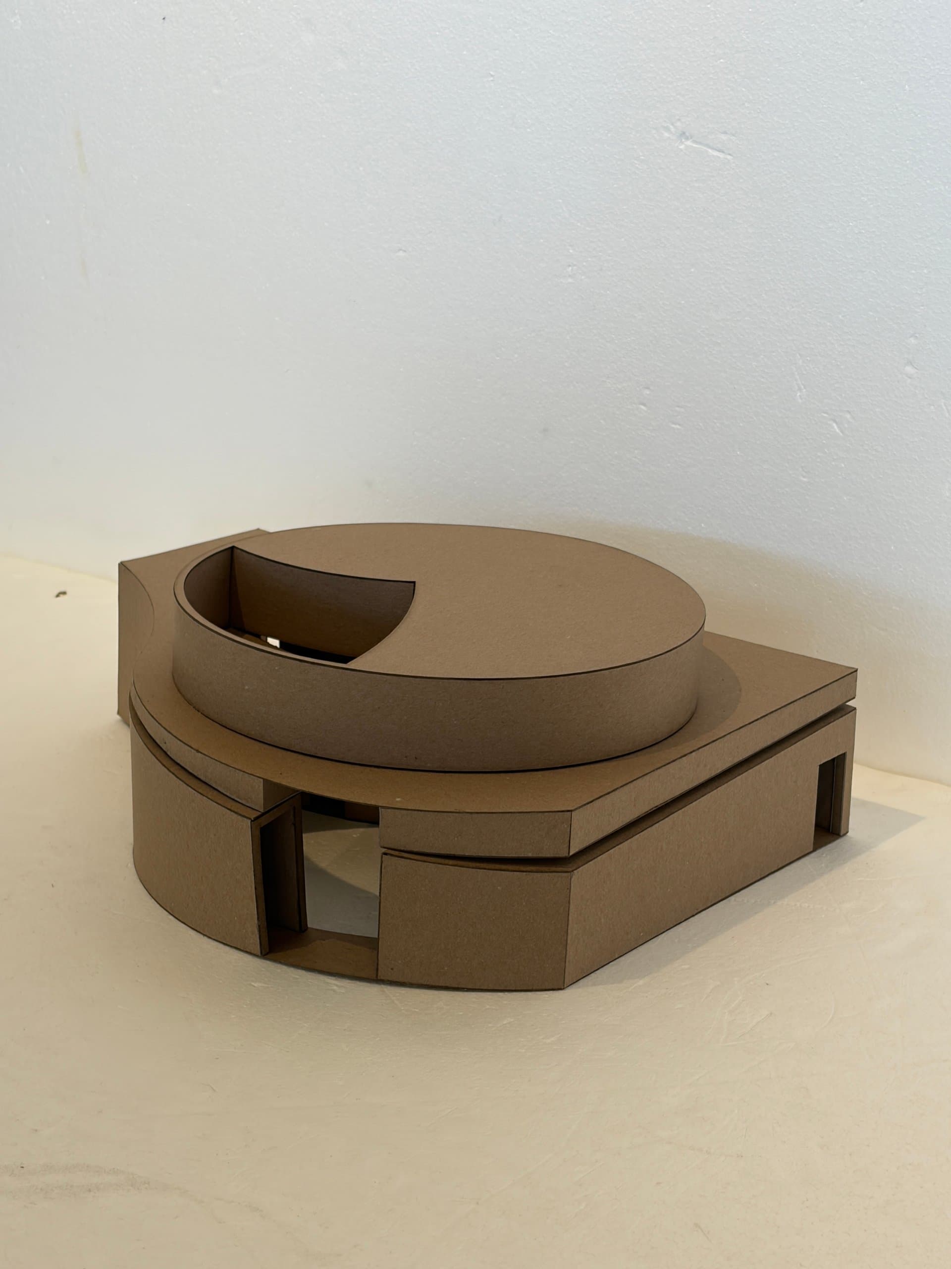 Photo of the cardboard model of the Wurster Courtyard redesign, showing its curved drum volume and carved-out entrance