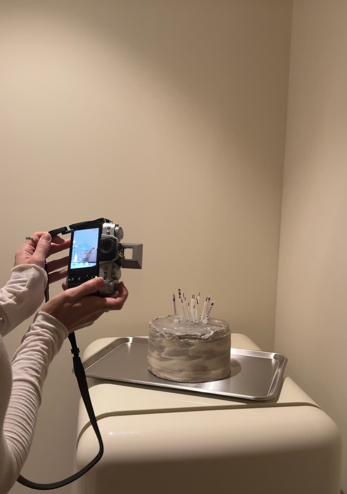 The cake being photographed on a compact camera in the treatment room