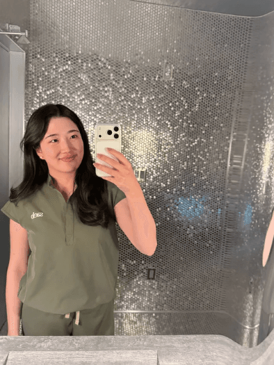 A mirror selfie taken against a textured silver wall