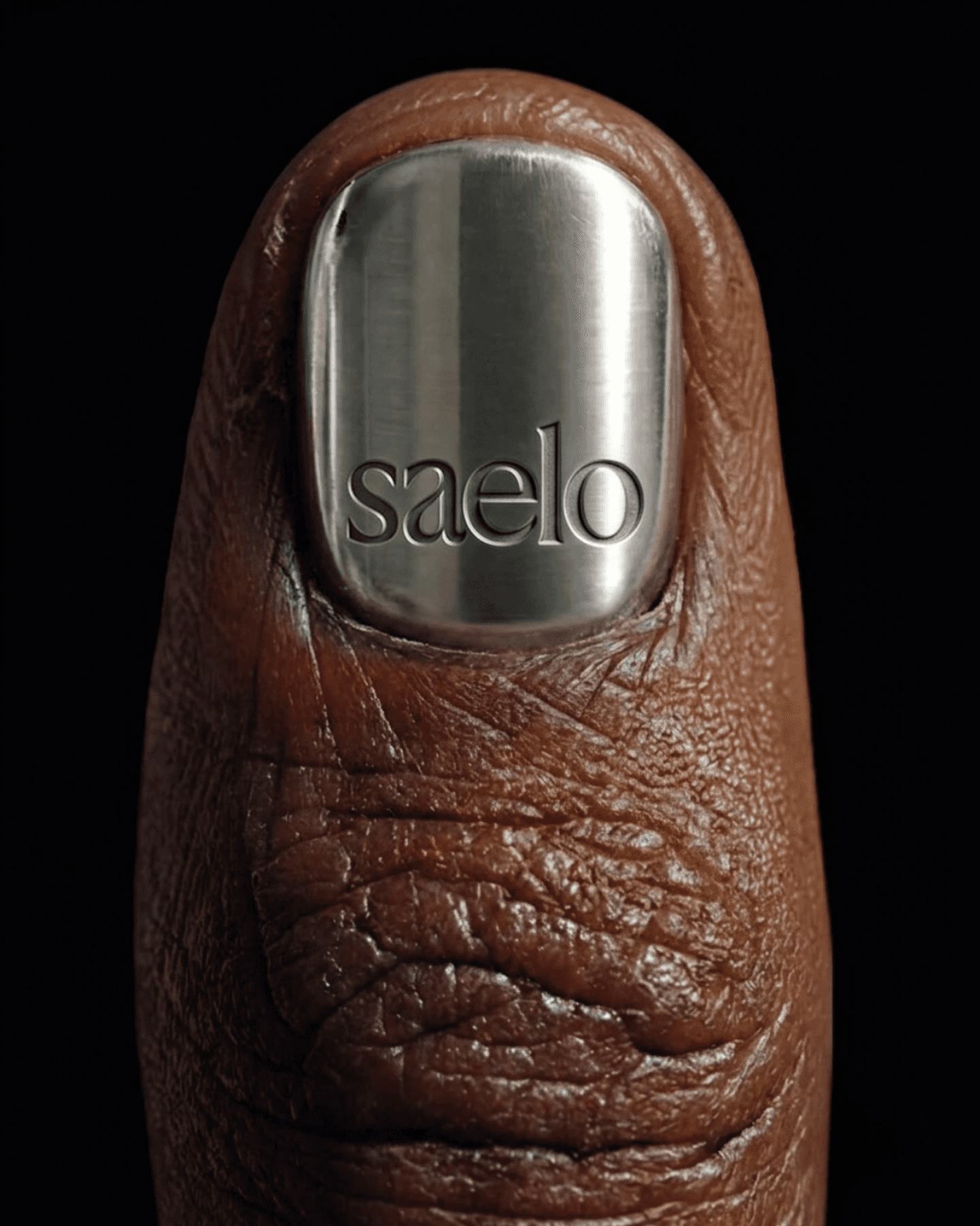 Brown fingernail detail styled for a Saelo social post